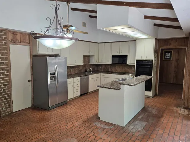 a kitchen with granite countertop a sink and a stove