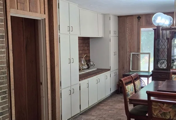 a hallway with dining area and chandelier