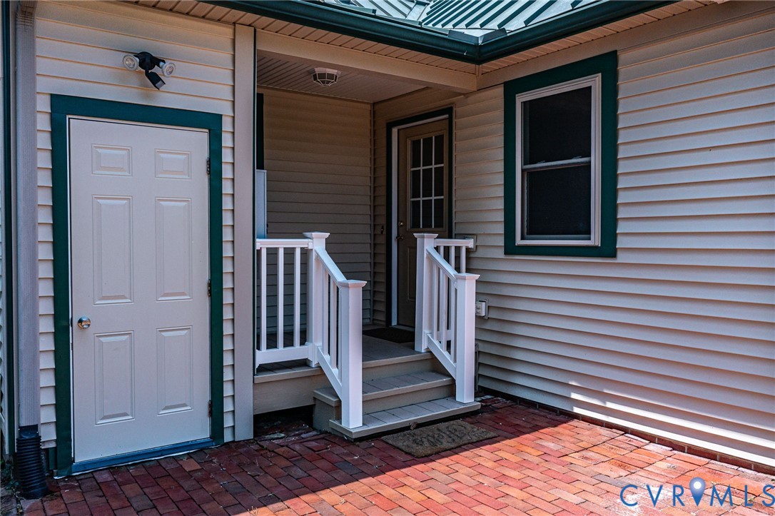 618 Main Street Reedville, VA 22539 - Photo 41 of 54 Brick paver patio with steps leading to an entry d