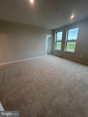a view of an empty room with windows and closet