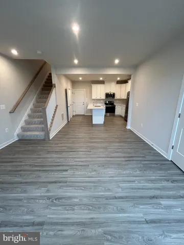 a kitchen with stainless steel appliances kitchen island granite countertop a refrigerator and a stove top oven
