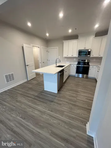 a view of walk in closet with wooden floor