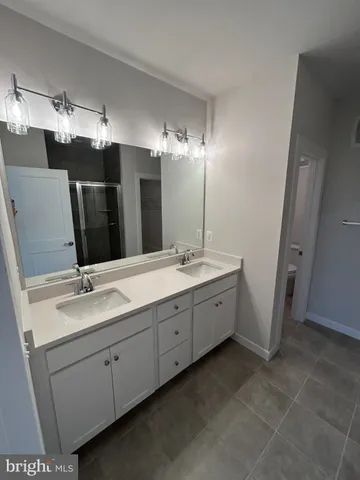 a bathroom with double sink and a mirror