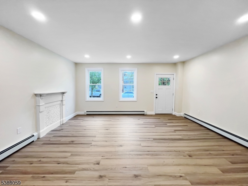 86 Heckman Street Phillipsburg, NJ 08865 - Photo 4 of 24 an empty room with wooden floor and windows