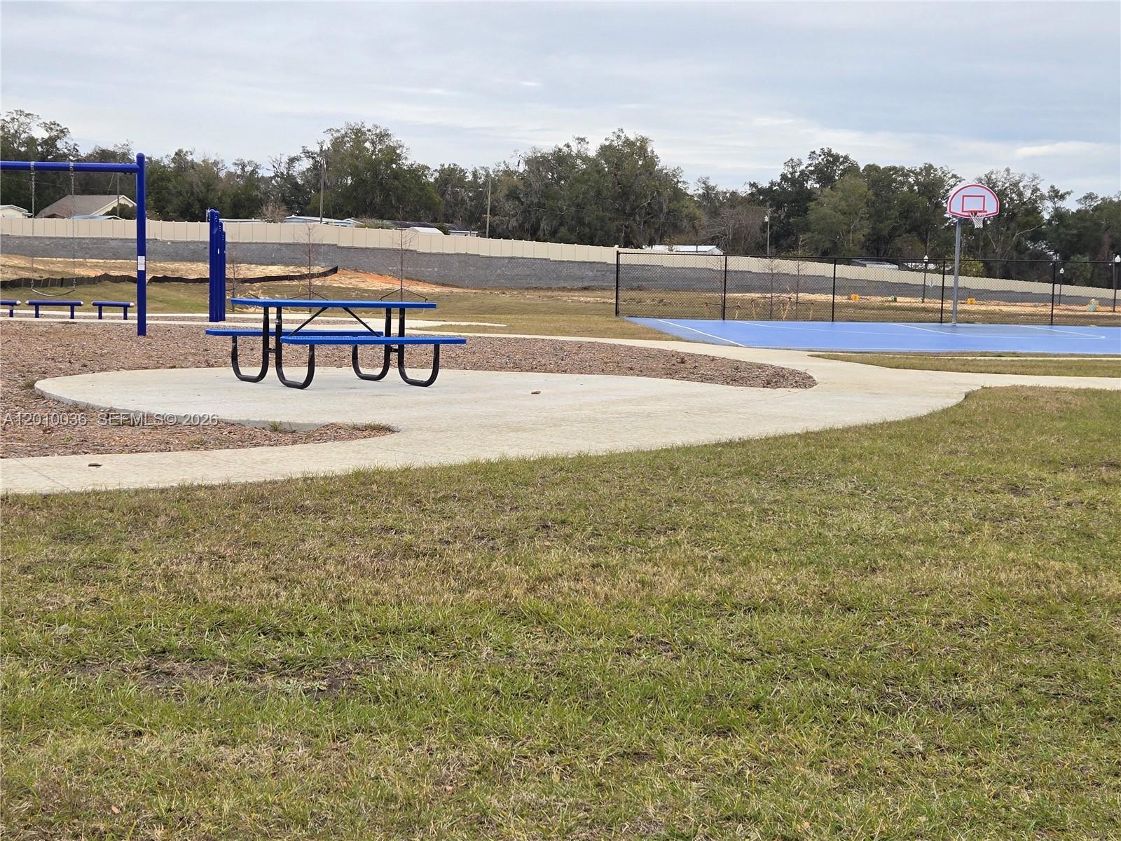 9871 Southeast 161st Lane Road Summerfield, FL 34491 - Photo 27 of 31 a view of a swimming pool with a bench and lake view