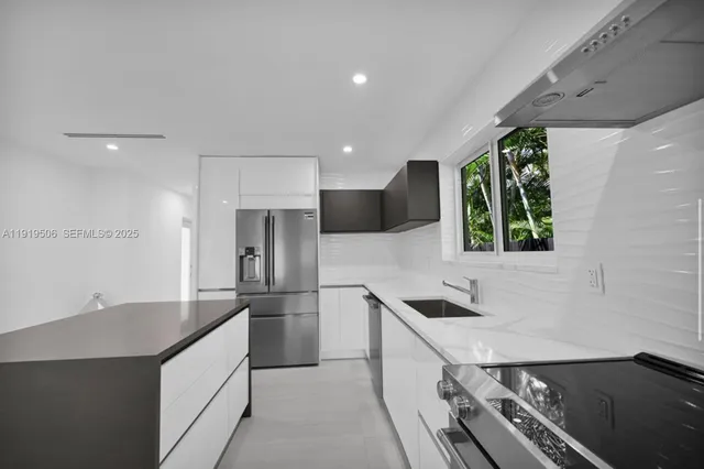 a kitchen with stainless steel appliances granite countertop a sink and a refrigerator