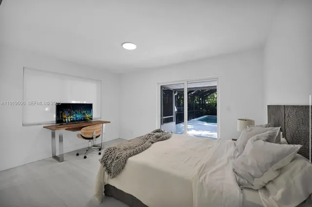 a bedroom with a bed and large windows