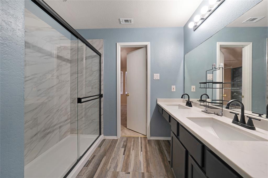 13241 Ridgepointe Road Fort Worth, TX 76244 - Photo 24 of 31 a bathroom with a double vanity sink a mirror and a shower