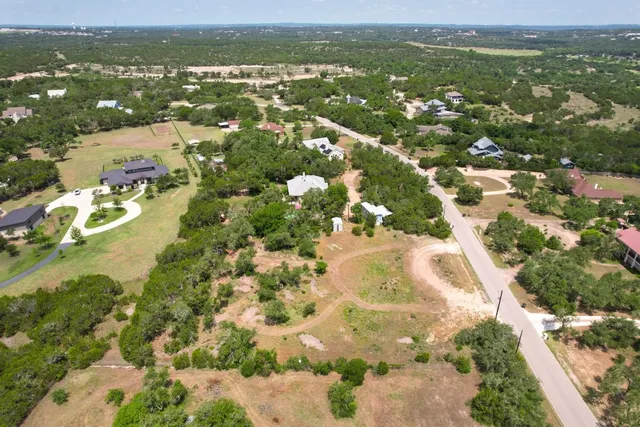 an aerial view of residential houses with outdoor space and trees