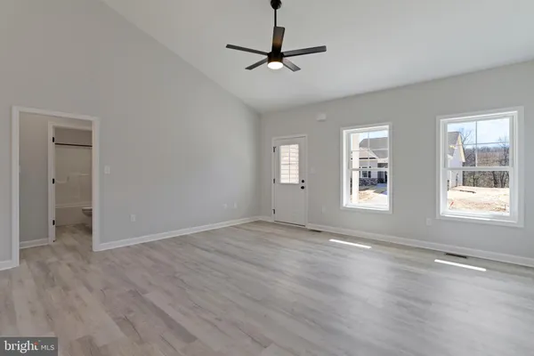 a kitchen with stainless steel appliances granite countertop a refrigerator a stove a sink and white cabinets