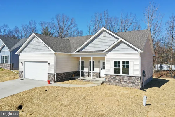a view of a white house with a yard and couches chairs
