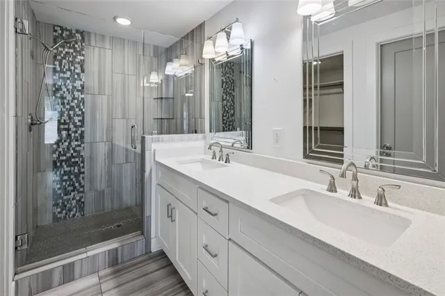 a bathroom with a double vanity sink mirror and shower