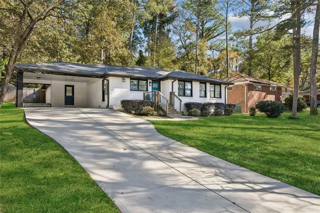 a front view of a house with a yard and trees