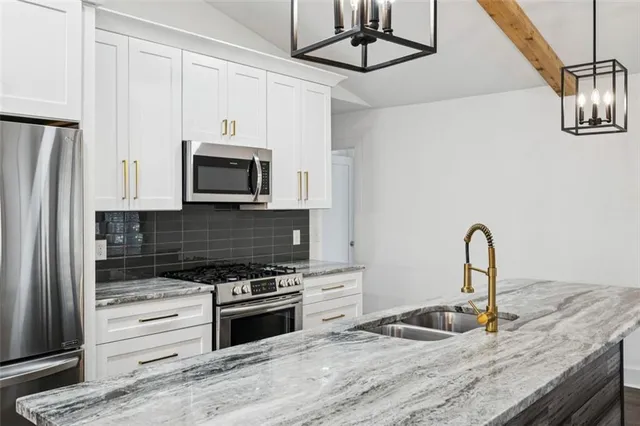 a kitchen with granite countertop a stove and a microwave
