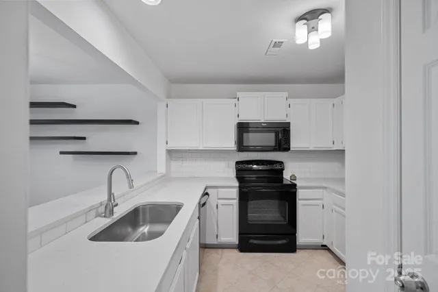 a kitchen with white cabinets and stainless steel appliances