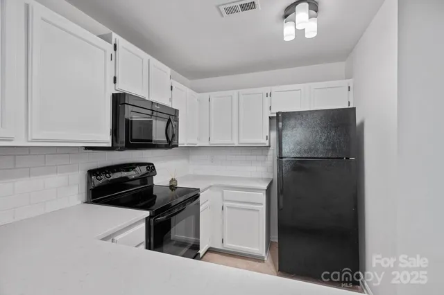 a kitchen with a refrigerator and a stove top oven