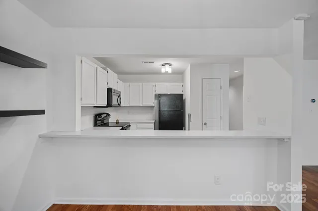 a large white kitchen with stainless steel appliances