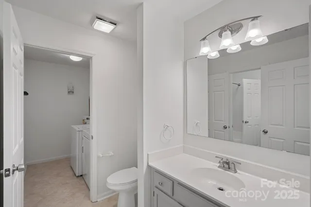 a bathroom with a sink a toilet and a large mirror