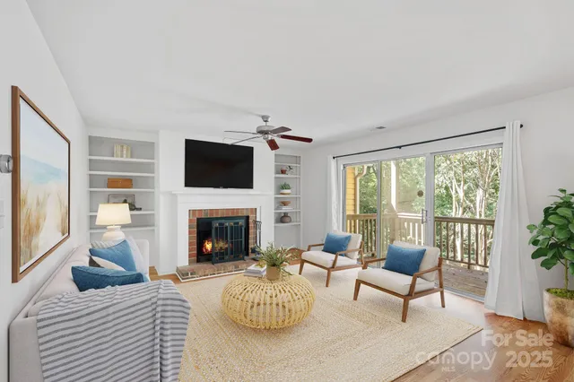 a living room with furniture a fireplace and a floor to ceiling window