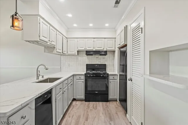 a kitchen with a sink appliances and cabinets