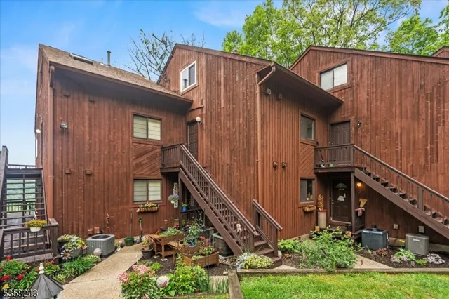 a view of a house with brick walls and a yard with plants