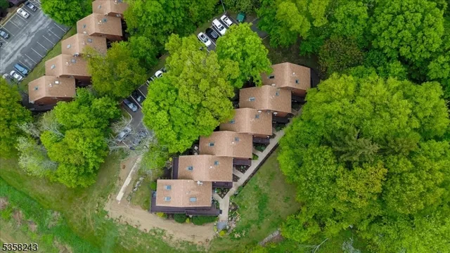 an aerial view of residential house with outdoor space and trees all around