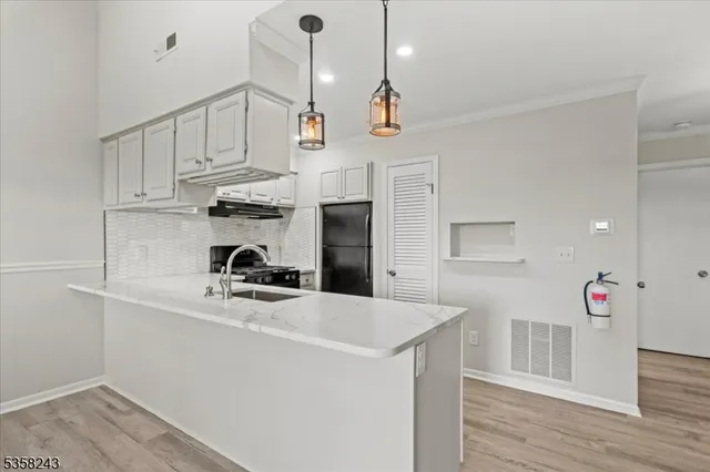 a kitchen with stainless steel appliances a sink a stove and cabinets