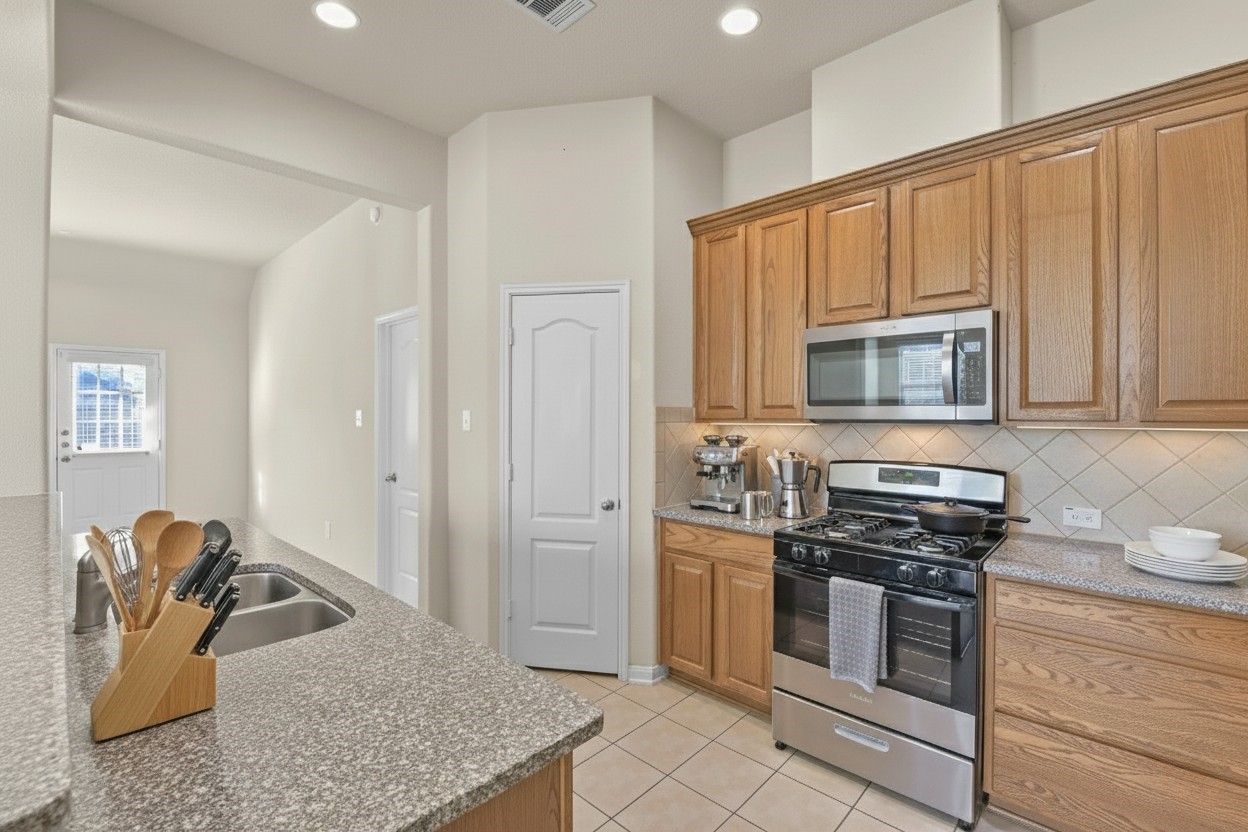 39 Butternut Grove Place Tomball, TX 77375 - Photo 11 of 35 a kitchen with stainless steel appliances granite countertop a stove microwave and a sink