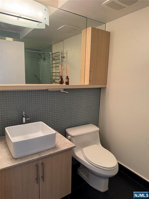 310 Cliff Lane, Unit 4E Cliffside Park, NJ 07010 - Photo 22 of 37 a bathroom with a sink a toilet and mirror