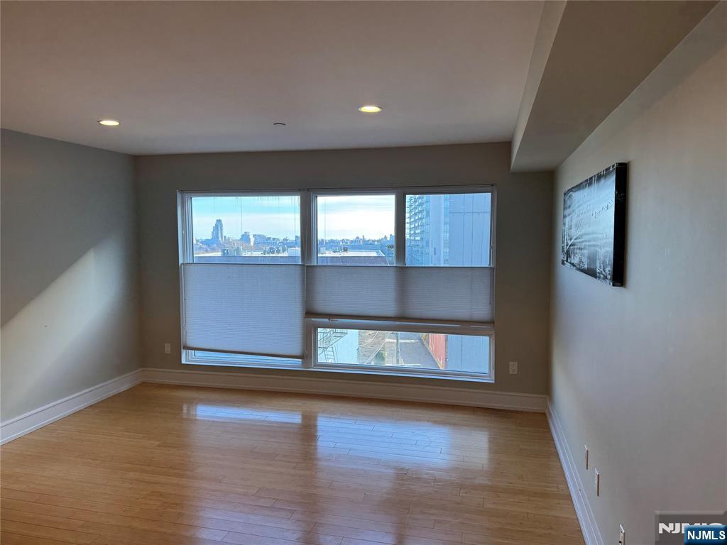 310 Cliff Lane, Unit 4E Cliffside Park, NJ 07010 - Photo 9 of 37 an empty room with wooden floor and windows