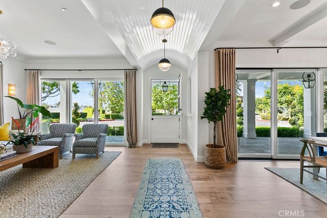 a living room with furniture large window and wooden floor