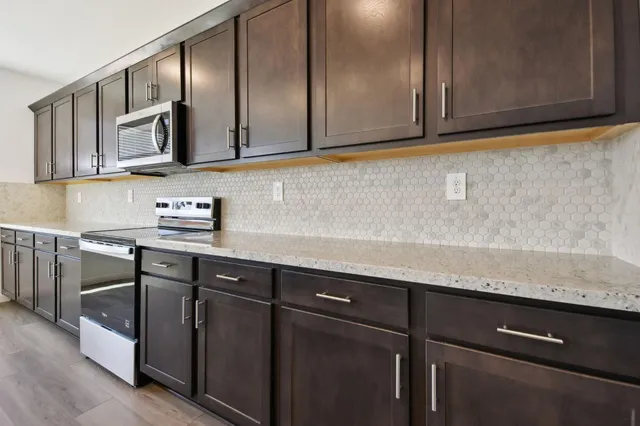 a kitchen with stainless steel appliances granite countertop a sink and a microwave