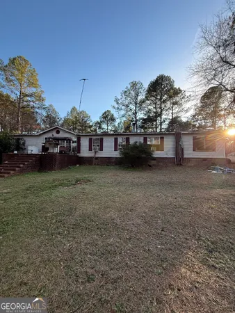 a view of a house with a yard and sitting area