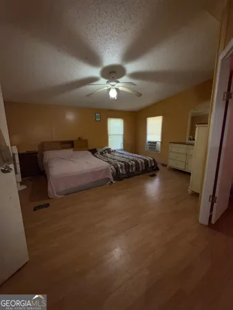 a spacious bedroom with a bed and a ceiling fan