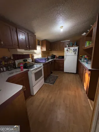 a kitchen with stainless steel appliances granite countertop a stove refrigerator sink and cabinets