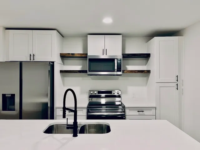 a kitchen with stainless steel appliances a sink a stove and a refrigerator