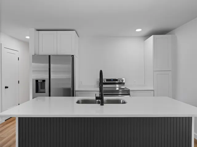 a kitchen with a refrigerator and white cabinets