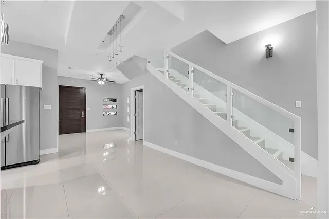 a view of a hallway with entryway and white walls