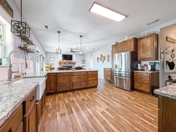 a kitchen with stainless steel appliances kitchen island granite countertop a refrigerator a stove and a sink