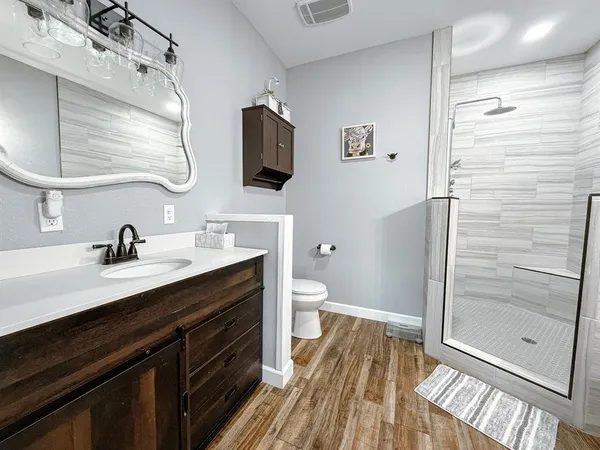 a bathroom with a granite countertop sink toilet and shower
