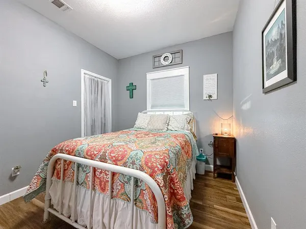 a bedroom with a bed and wooden floor
