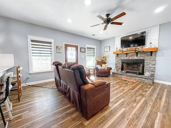 a living room with furniture a fireplace and a flat screen tv