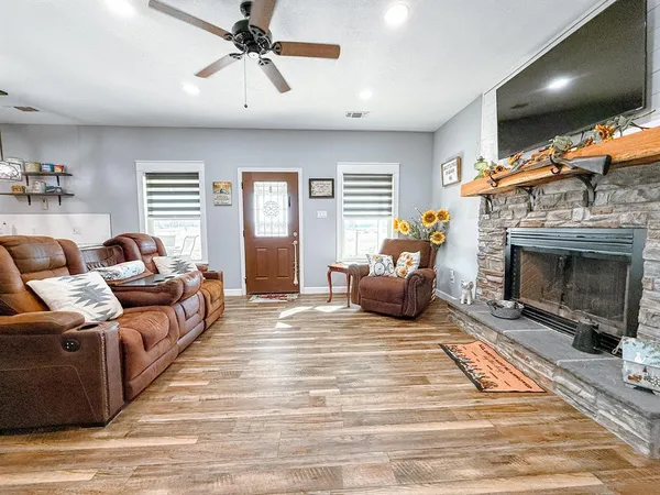 a living room with furniture a flat screen tv and a fireplace