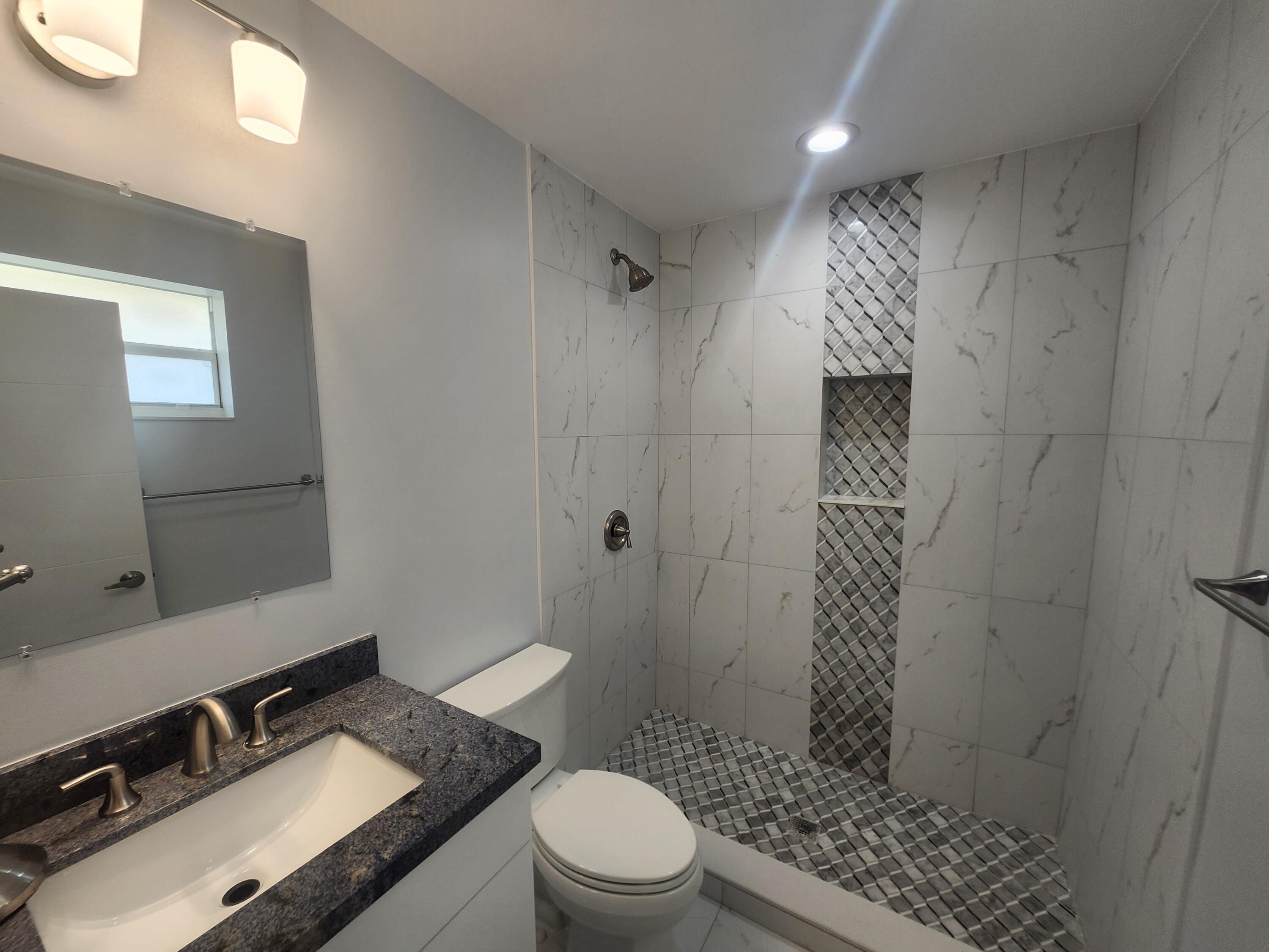 511 Northwest 60th Way, Unit EAST APARTMENT Hollywood, FL 33024 - Photo 12 of 15 a bathroom with a granite countertop sink toilet and shower