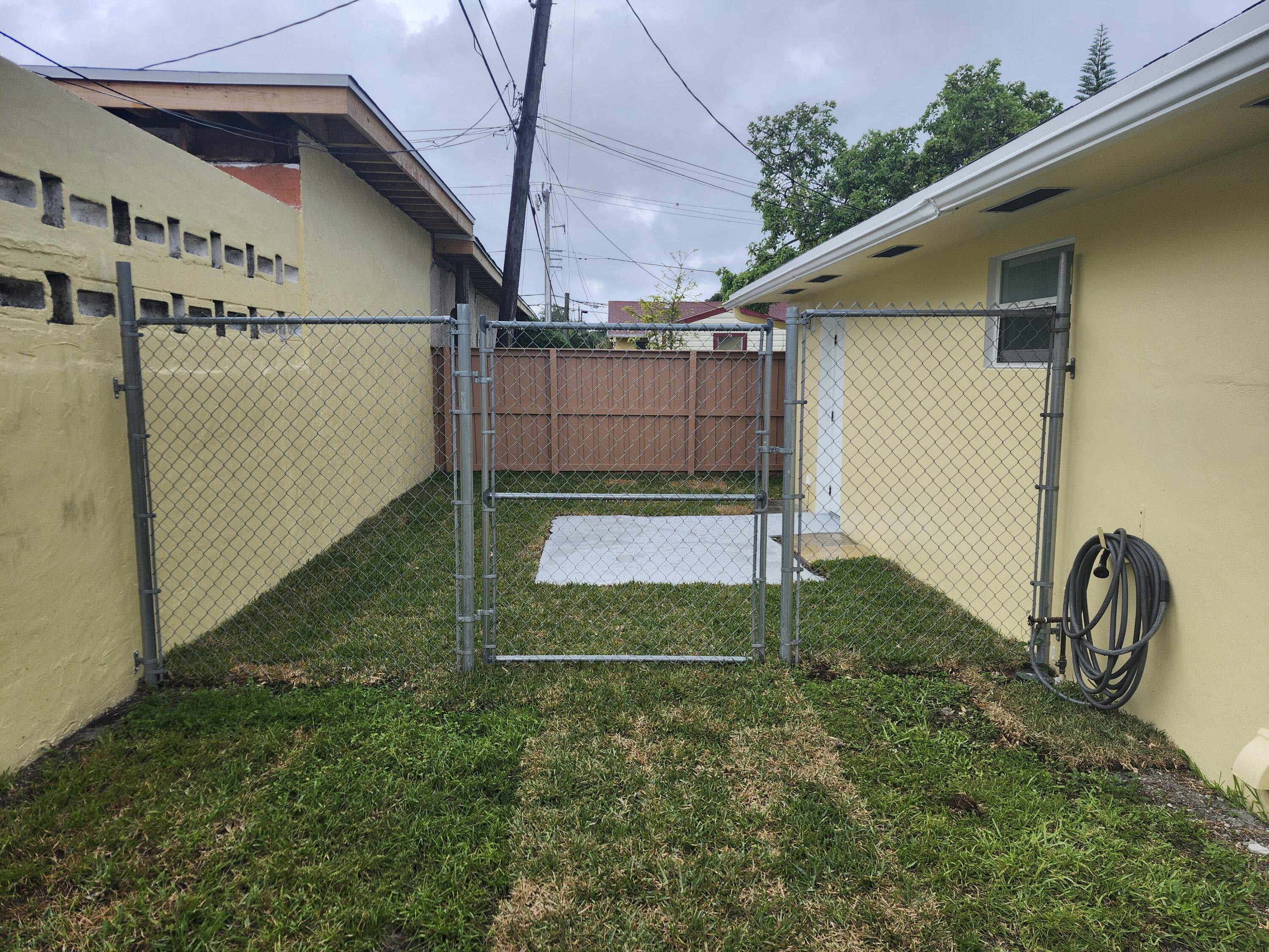 511 Northwest 60th Way, Unit EAST APARTMENT Hollywood, FL 33024 - Photo 15 of 15 a backyard of a house with wooden floor and fence
