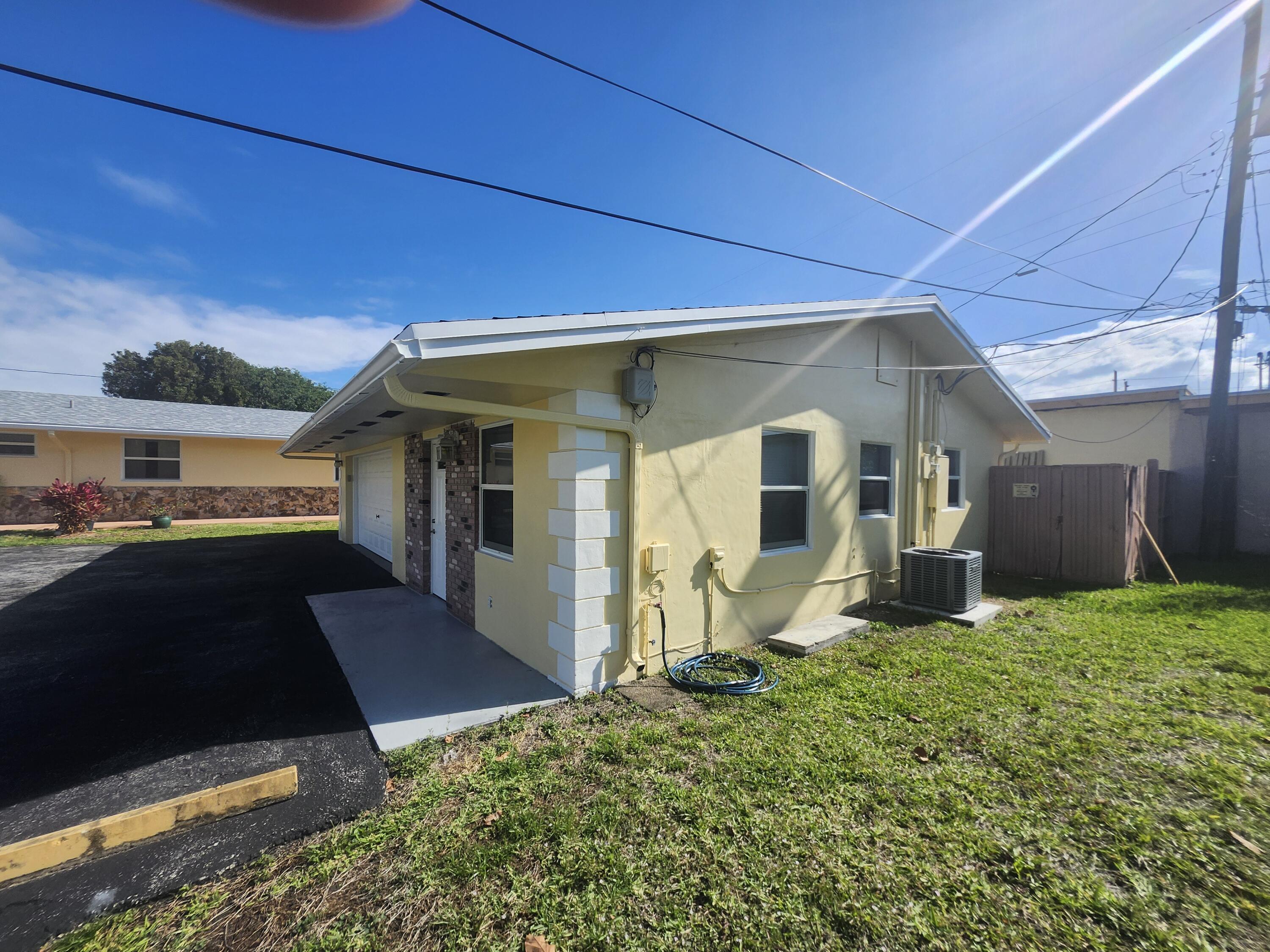 511 Northwest 60th Way, Unit EAST APARTMENT Hollywood, FL 33024 - Photo 2 of 15 a front view of a house with a yard