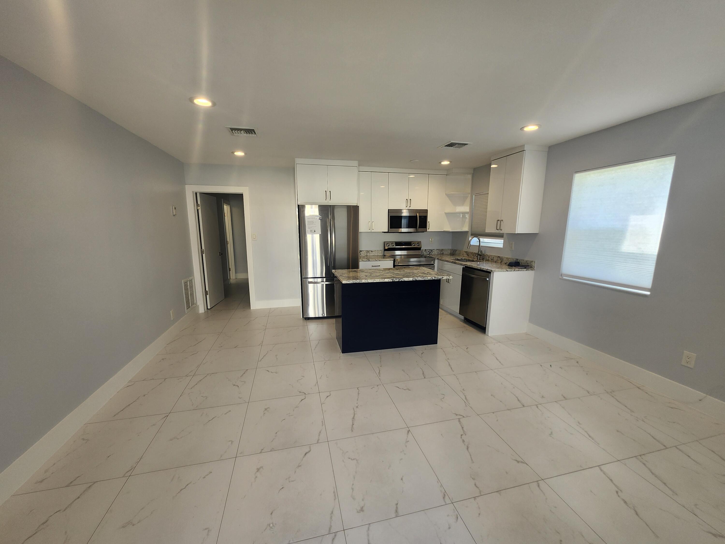 511 Northwest 60th Way, Unit EAST APARTMENT Hollywood, FL 33024 - Photo 5 of 15 a kitchen with stainless steel appliances a refrigerator sink and stove