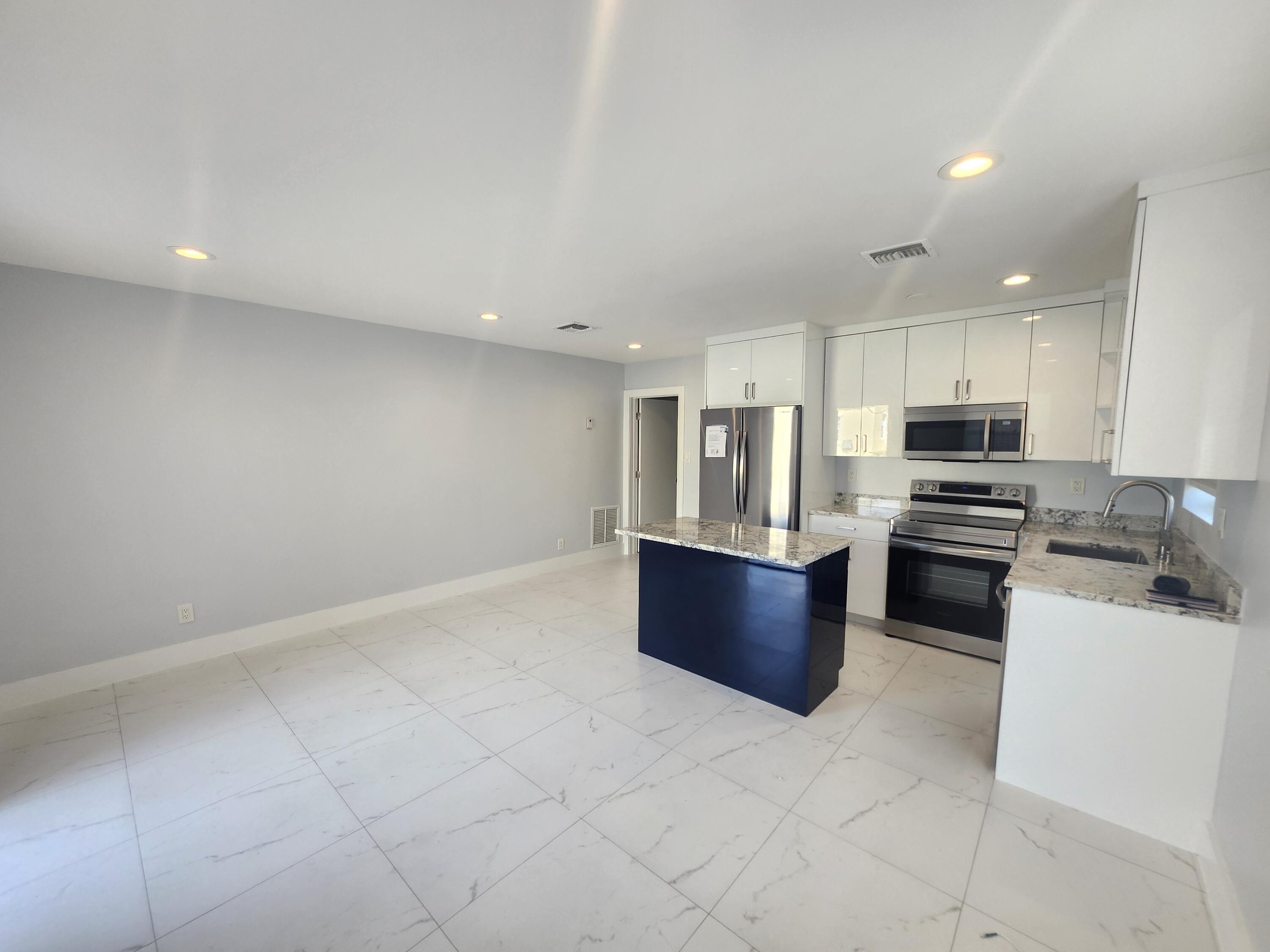 511 Northwest 60th Way, Unit EAST APARTMENT Hollywood, FL 33024 - Photo 6 of 15 a kitchen with stainless steel appliances granite countertop a stove top oven a sink and dishwasher
