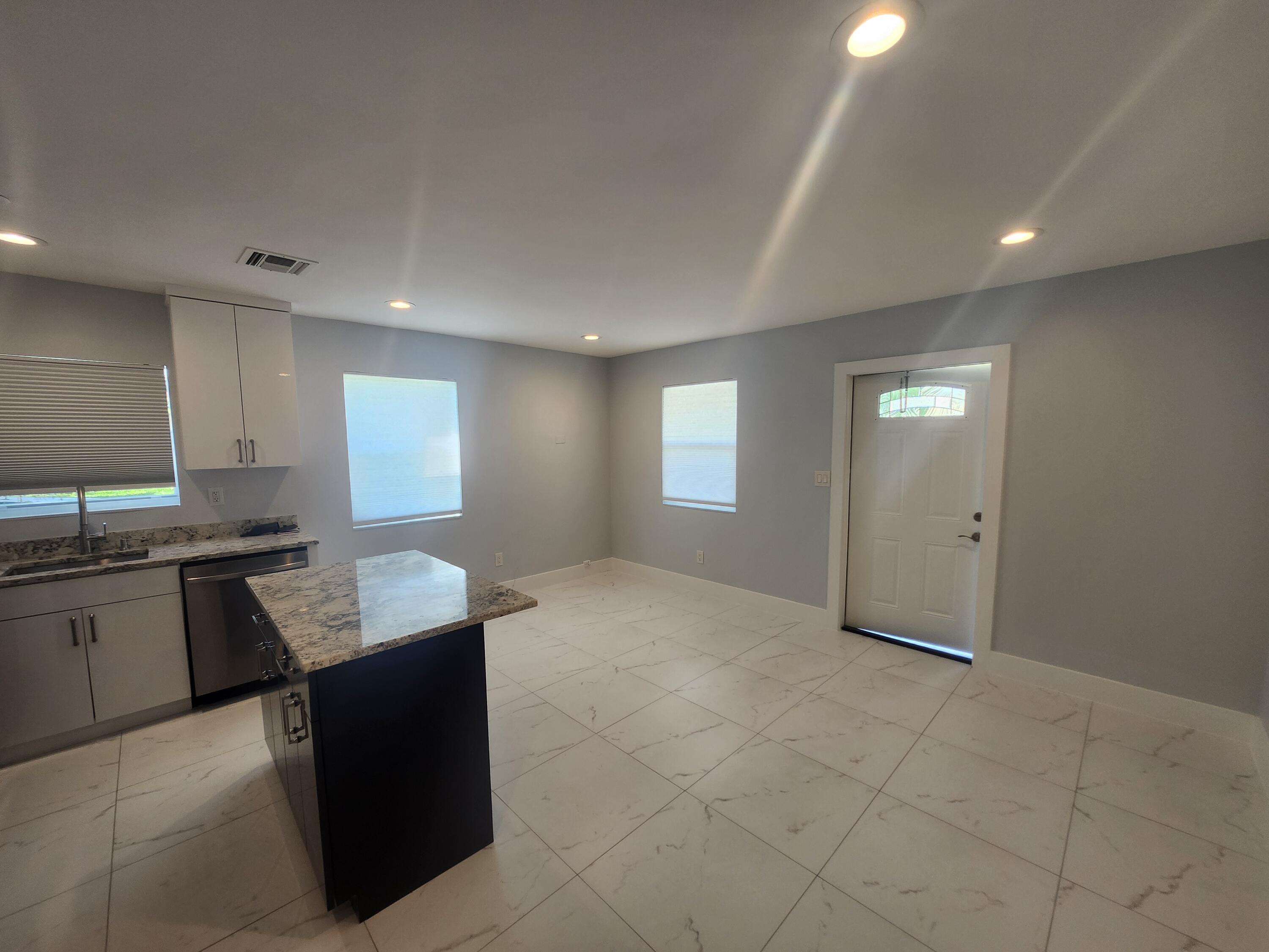 511 Northwest 60th Way, Unit EAST APARTMENT Hollywood, FL 33024 - Photo 7 of 15 a kitchen with kitchen island granite countertop a sink counter top space and appliances