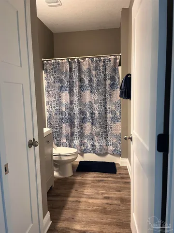 a bathroom with a toilet and a shower curtain